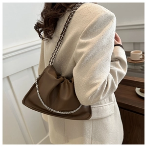 Sac nuage en cuir marron avec design plissé et bandoulière chaîne sur un modèle