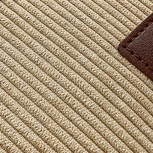 Detail der beigen Cordstruktur mit vertikalen Streifen und Leder-Applikationsdetails