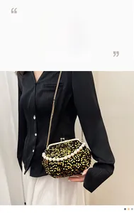 Gros plan du sac de soirée à paillettes noir et or avec poignée en perles et fermoir