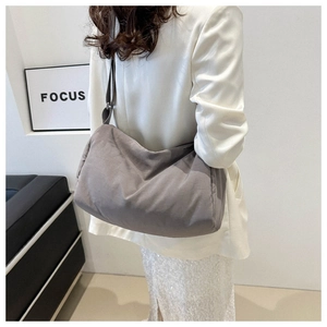 Detail view of a large grey nylon hobo bag featuring a soft pleated structure and wide strap