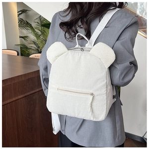 Détail du sac à dos en velours côtelé blanc avec oreilles d'ours 3D et poche zippée