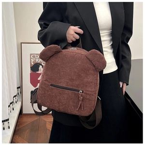 Détail d'un sac à dos en velours côtelé marron avec oreilles d'ours et tissu texturé
