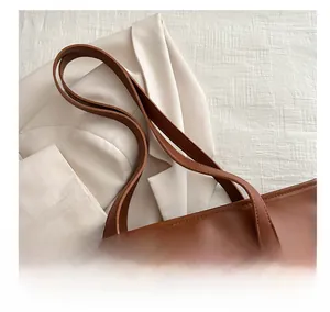 Dettaglio del manico della borsa tote color caramello con trama in pelle liscia