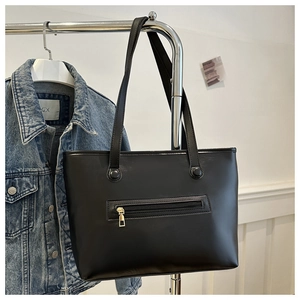 Dettaglio borsa tote in pelle PU nera con tasca frontale dorata e spalline sottili