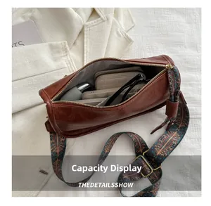 Vue intérieure du sac Boston rétro marron montrant le rangement pour lunettes et portefeuille