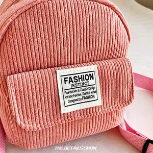 Detail of pink corduroy fabric and fashion label on a mini minimalist backpack