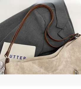 Detailed view of the beige tote bag textured synthetic leather and brown strap