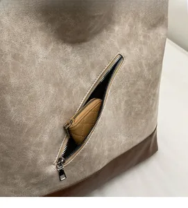 Detail view of large tote bag with beige marble texture, dark base and zipper pocket