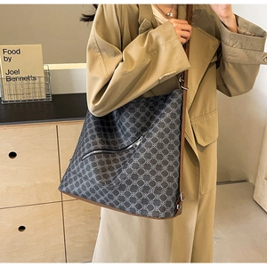 Detail of printed tote bag with geometric patterns and brown leather shoulder strap