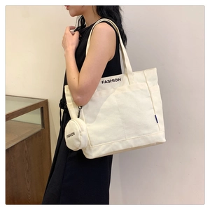Detalle del bolso tote de lona con bolsillo lateral y monedero pequeño a juego con logo FASHION