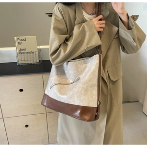 Detail of contrast color tote bag with beige leather and brown texture on model
