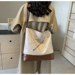 Detailed back view of a large cream and brown tote bag with metal zipper detail
