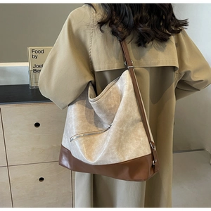 Rear view of a large two-tone cream and brown tote bag styled on a female model