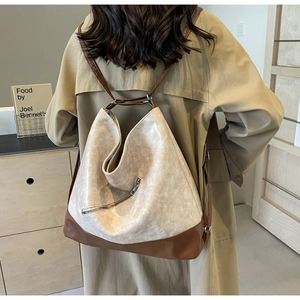 Detail of a large retro two-tone tote bag in cream and brown PU leather on a model