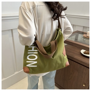 Détail du cabas en toile verte avec imprimé FASHION et finitions en cuir marron chic