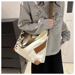 Détail du sac cabas en toile blanche avec texte NOTION noir et bandoulière marron