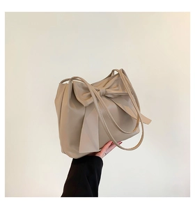 Detailansicht der beigen PU-Lederhandtasche mit großer Schleife und matter Oberfläche