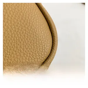 Macro shot of high-quality camel lychee grain leather texture and durable stitching