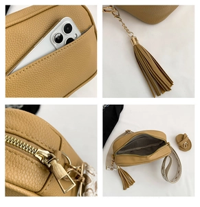 Detail view of brown pebbled leather bag with tassels and embroidered shoulder strap