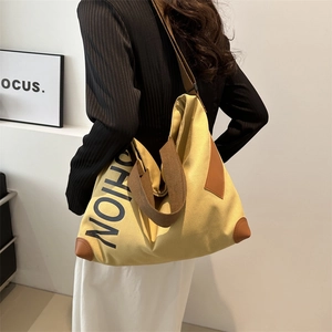 Sac cabas en toile jaune moutarde avec imprimé FASHION et anses en cuir marron sur mannequin