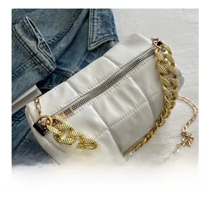 Detail showing white quilted crossbody bag with chunky gold chain and metal zipper