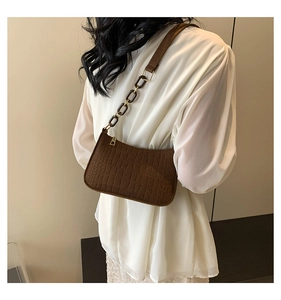Close-up of brown crocodile pattern baguette bag with vintage resin chain strap