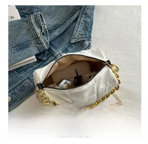 Detailed interior of a white quilted chain bag showing space for lipstick and cosmetics
