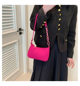 Schultertasche mit Krokodilprägung in Pink mit Acryl-Kettenriemen in der Seitenansicht