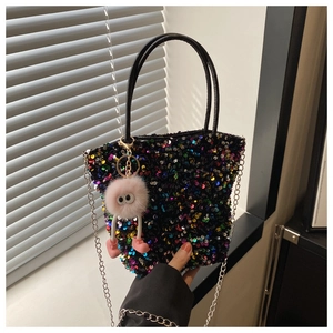 Détail du sac à main à paillettes noires scintillantes avec breloque monstre en peluche