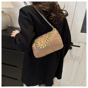Detail of khaki quilted square bag featuring a chunky gold chain and soft leather texture