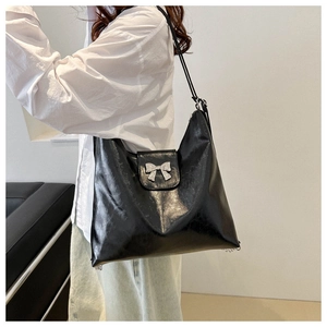 Vue détaillée du grand sac cabas noir avec décoration en forme de nœud métallique argenté