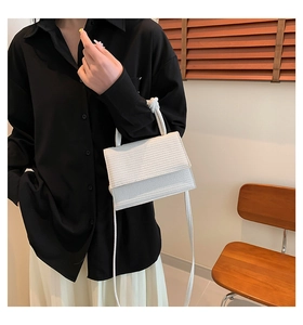 Detail of the white textured mini handbag showing the fine horizontal grain and handle