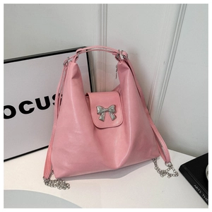 Vue détaillée du sac cabas rose en cuir avec boucle nœud argentée et chaîne métallique