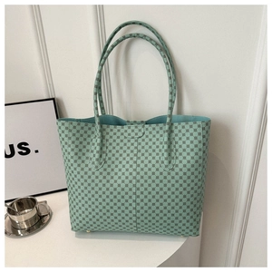 Detalle del bolso tote verde menta con diseño geométrico y pies metálicos de protección