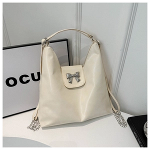 Détail du sac à épaule blanc crème en cuir avec nœud argenté et chaîne métallique