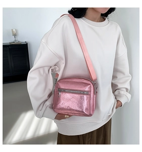 Dettaglio borsa a tracolla quadrata rosa metallizzata con cinturino largo e fibbie argento