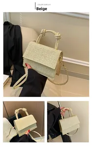 Detail of cream woven handbag showing knotted handle and textured crossbody strap
