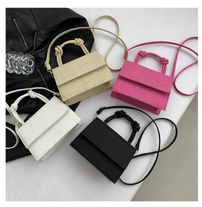 Detailed view of woven flap square bags in white, beige, rose pink, and black colors
