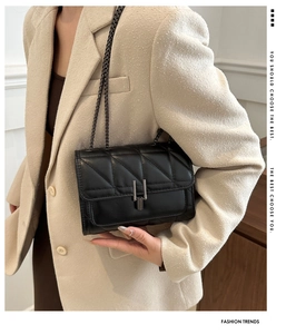 Détail du sac bandoulière matelassé noir avec boucle géométrique et bandoulière chaîne