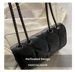 Détails des œillets métalliques gris foncé et motif matelassé sur un sac bandoulière noir