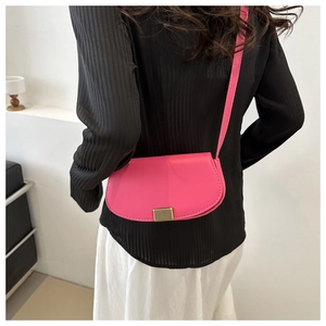 Detail of rose pink saddle bag with vintage golden metal buckle on model