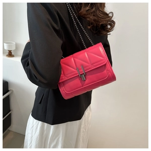 Détail du sac matelassé fuchsia porté par le mannequin, montrant taille et texture