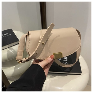 Detail of beige vintage saddle bag with golden metal clasp and fine stitching accents