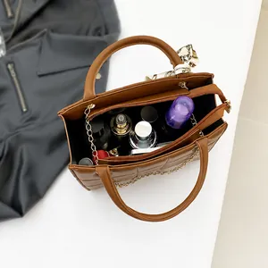 Detailansicht der geräumigen braunen Stepptasche mit Innenraumkapazität und Seidentuch