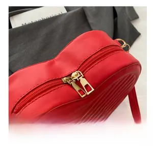 Détail du sac rouge en forme de cœur avec double fermeture éclair dorée et matelassage en V
