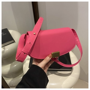 Detail view of pink saddle bag with golden rectangular buckle and smooth leather texture