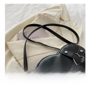 Detailansicht der schwarzen Herz-Tasche mit Silbernieten und verstellbarem Gurt