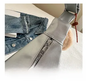 Vue détaillée d'un sac cabas gris argenté avec fermeture éclair en métal lisse