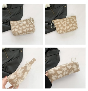 Multi-angle view of beige canvas makeup bag with heart patterns and pearl handle detail
