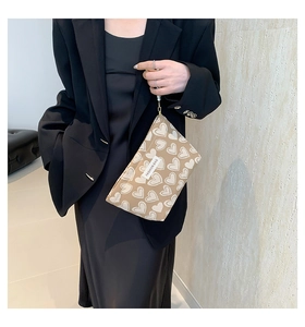 Detail der Make-up-Tasche aus Segeltuch mit Herzmuster und Perlenband am Model